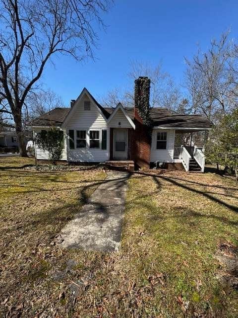 view of front of home with a front yard and covered porch