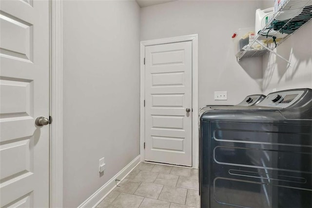 washroom featuring light tile patterned floors and washer and clothes dryer