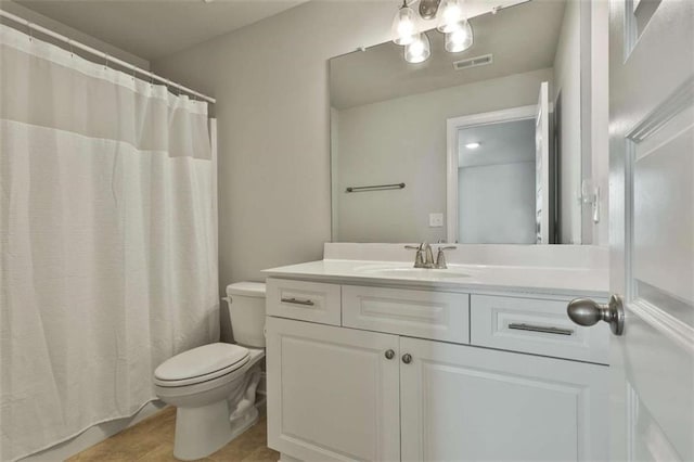 bathroom featuring vanity, curtained shower, and toilet