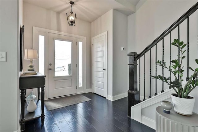 entrance foyer featuring dark hardwood / wood-style floors and a notable chandelier