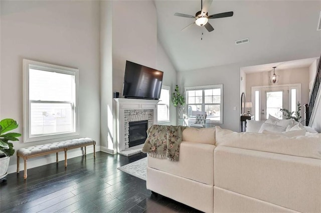 living room featuring a fireplace, high vaulted ceiling, dark hardwood / wood-style floors, and ceiling fan