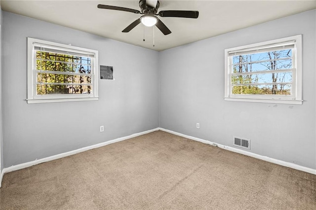 spare room featuring carpet flooring, a wealth of natural light, and ceiling fan