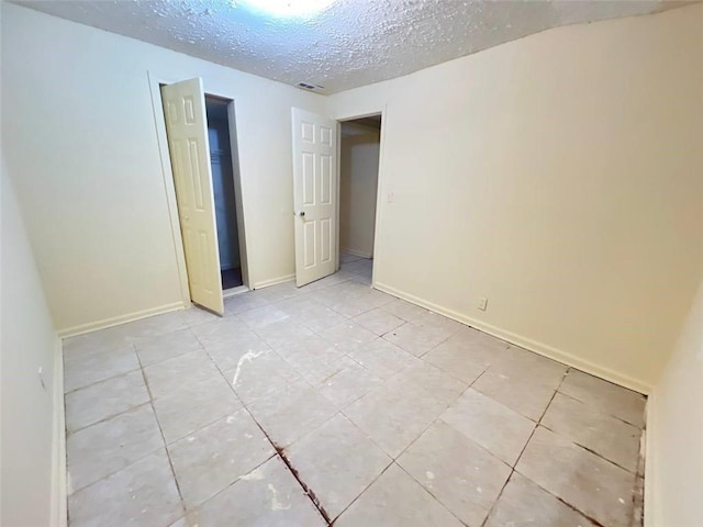 unfurnished room featuring a textured ceiling