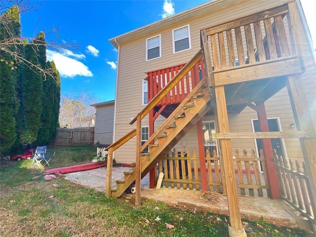 rear view of property featuring a patio area, a deck, and a yard