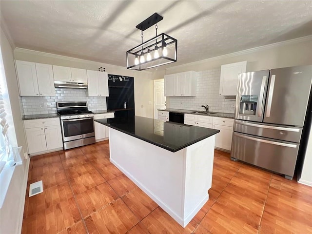 kitchen with white cabinetry, sink, decorative light fixtures, a kitchen island, and appliances with stainless steel finishes