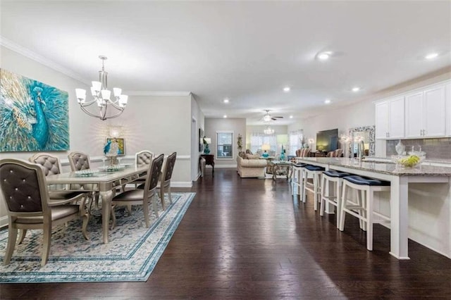 dining area featuring sink, ornamental molding, dark hardwood / wood-style floors, and ceiling fan with notable chandelier