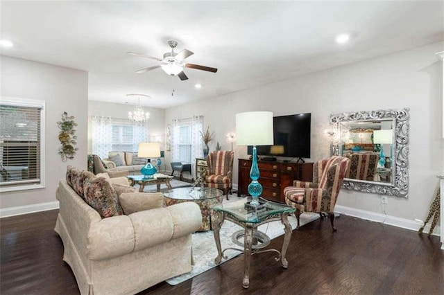 living room with ceiling fan with notable chandelier and dark wood-type flooring