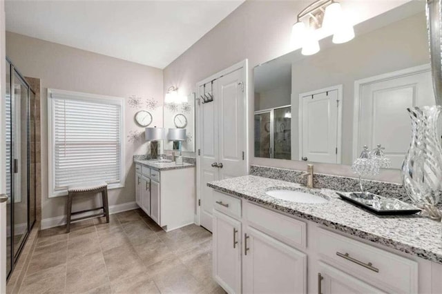 bathroom featuring tile patterned floors, vanity, and a shower with shower door