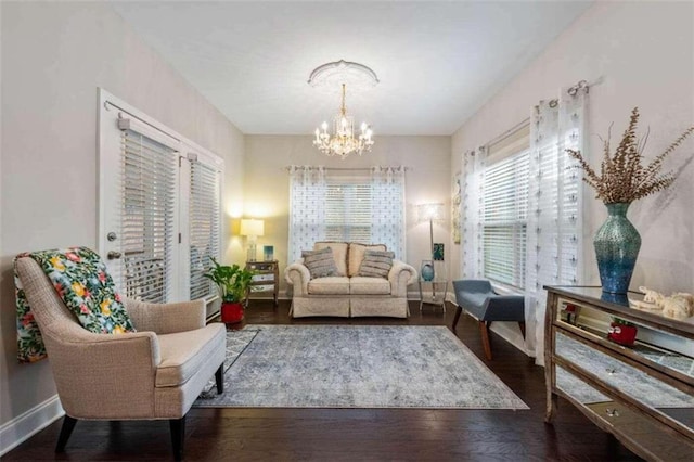 sitting room with a chandelier and dark hardwood / wood-style floors