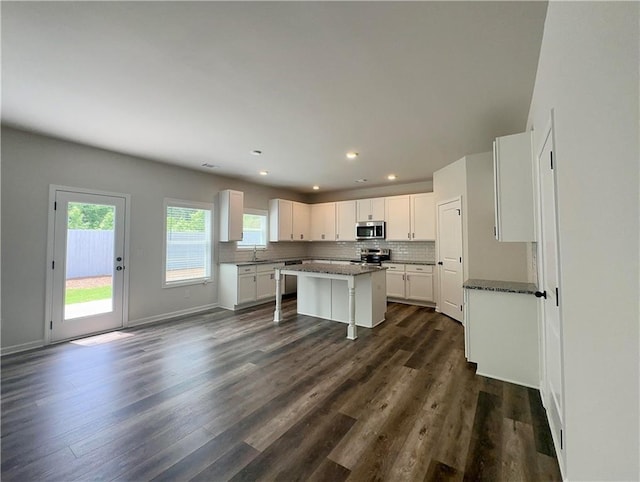 kitchen featuring a kitchen bar, white cabinets, stainless steel appliances, and a kitchen island