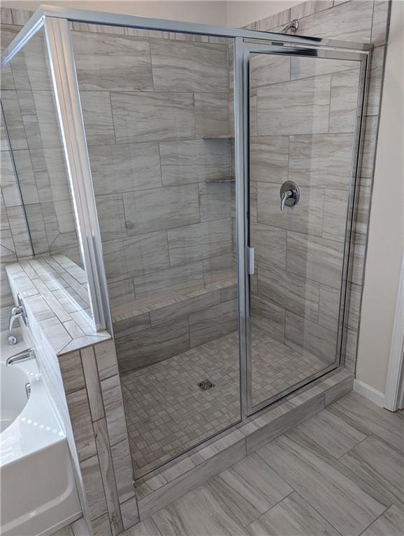 bathroom featuring separate shower and tub