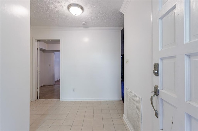 tiled empty room featuring crown molding and a textured ceiling