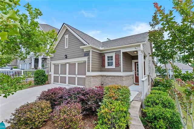 6469 Crosscreek Ln, Flowery Branch, GA 30542 - view of front of house with brick siding, concrete driveway, an attached garage, and roof with shingles