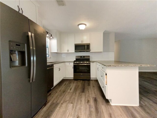 kitchen with white cabinetry, appliances with stainless steel finishes, and dark hardwood / wood-style floors