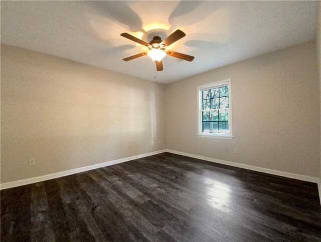 spare room with ceiling fan and dark hardwood / wood-style flooring