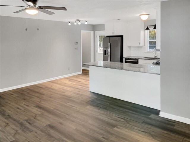 kitchen with dark hardwood / wood-style floors, white cabinetry, light stone countertops, and stainless steel fridge with ice dispenser