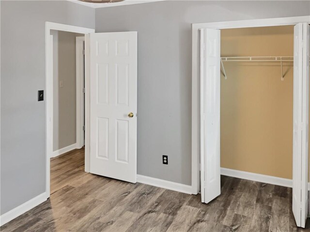 unfurnished bedroom with a closet and hardwood / wood-style flooring