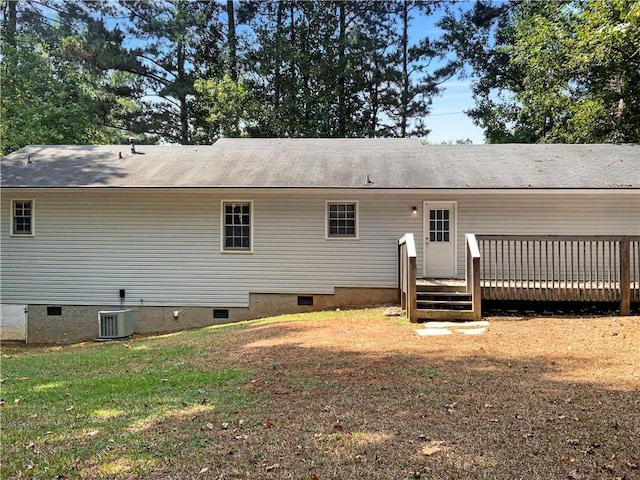 back of property with central AC unit, a wooden deck, and a yard