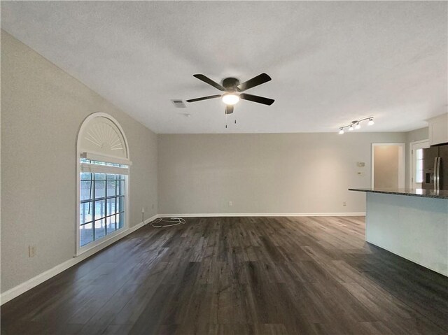 unfurnished living room featuring ceiling fan, a textured ceiling, and dark hardwood / wood-style floors