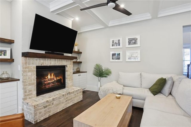living room with a brick fireplace, ceiling fan, dark wood finished floors, and coffered ceiling