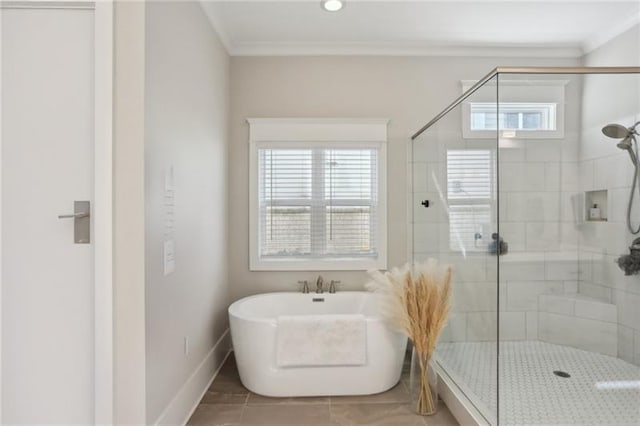 bathroom with crown molding, baseboards, a soaking tub, and a shower stall