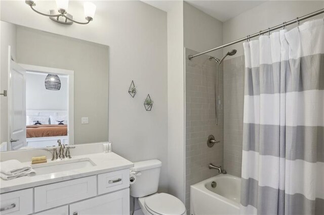 full bathroom featuring ensuite bathroom, toilet, shower / tub combo, and vanity