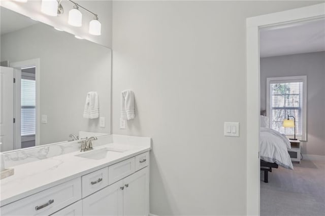 bathroom with connected bathroom, baseboards, and vanity