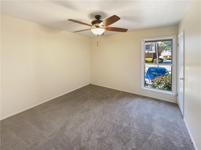 unfurnished room featuring dark colored carpet and ceiling fan