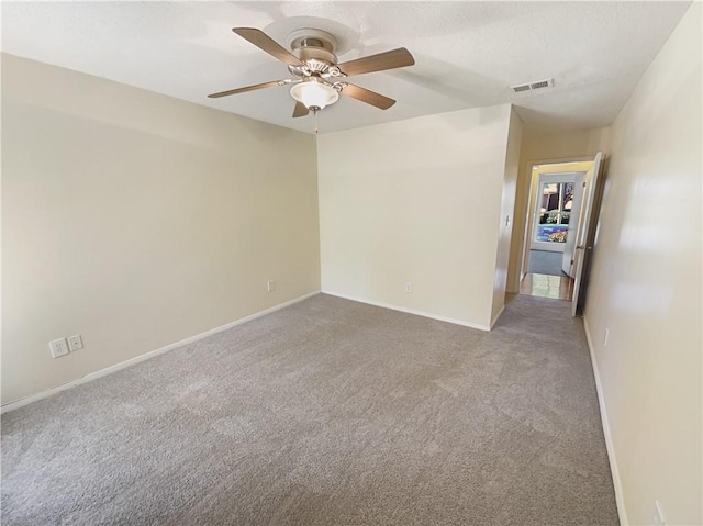 carpeted spare room featuring ceiling fan