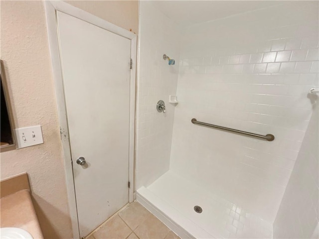 bathroom with tile patterned floors, a shower, and vanity