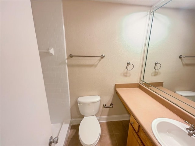 bathroom with a shower, vanity, tile patterned flooring, and toilet