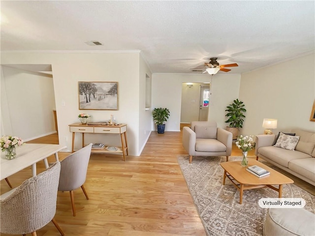 living room featuring ceiling fan, light hardwood / wood-style flooring, and ornamental molding