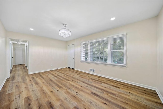 unfurnished dining area featuring attic access, light wood-style flooring, baseboards, and visible vents