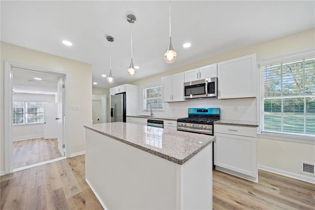 kitchen with white cabinetry, tasteful backsplash, visible vents, and appliances with stainless steel finishes