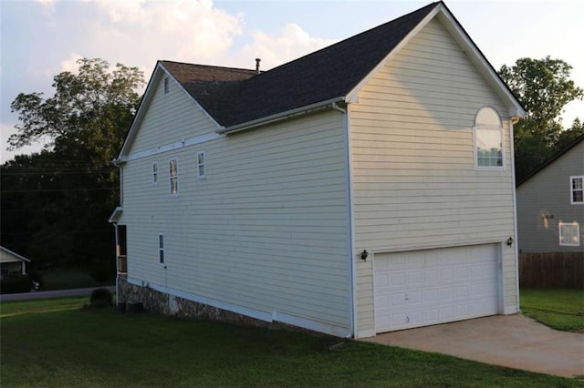 view of home's exterior with a garage and a yard