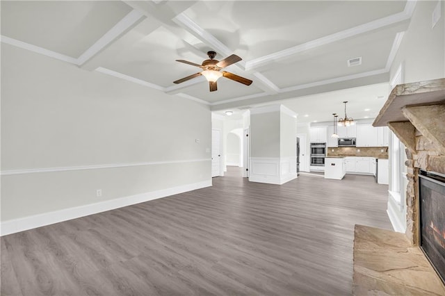 unfurnished living room with wood-type flooring, ornamental molding, a fireplace, and ceiling fan with notable chandelier