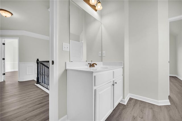 bathroom featuring ornamental molding, hardwood / wood-style flooring, and vanity