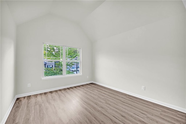 empty room featuring light hardwood / wood-style flooring and lofted ceiling