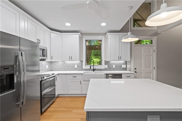 532 Coffee Cove Dr, Jasper, GA 30143 - kitchen with stainless steel appliances, a sink, light wood-style floors, decorative backsplash, and a center island