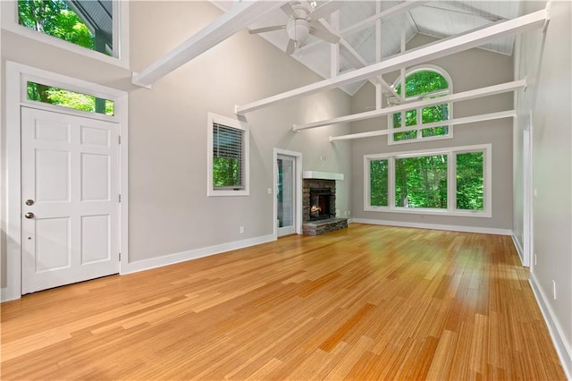 532 Coffee Cove Dr, Jasper, GA 30143 - unfurnished living room with high vaulted ceiling, baseboards, a ceiling fan, wood finished floors, and a stone fireplace