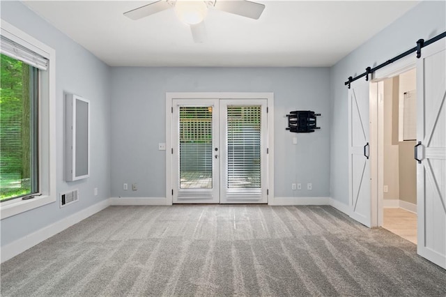 532 Coffee Cove Dr, Jasper, GA 30143 - carpeted spare room featuring a barn door, a ceiling fan, and baseboards