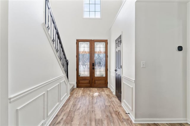 foyer featuring a healthy amount of sunlight, french doors, and light wood-type flooring