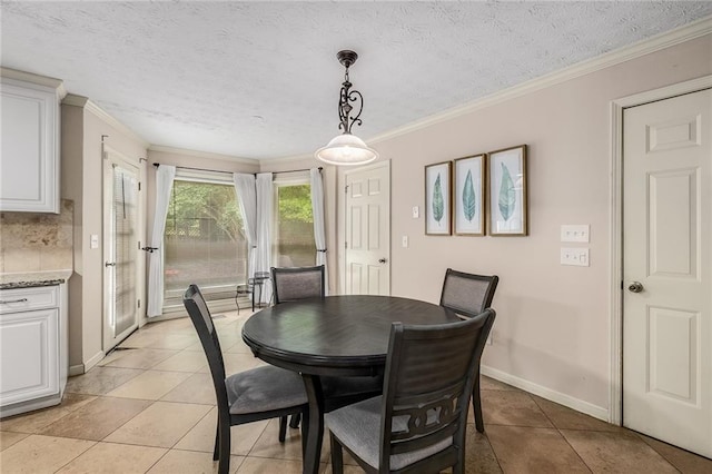 tiled dining room featuring a textured ceiling and ornamental molding