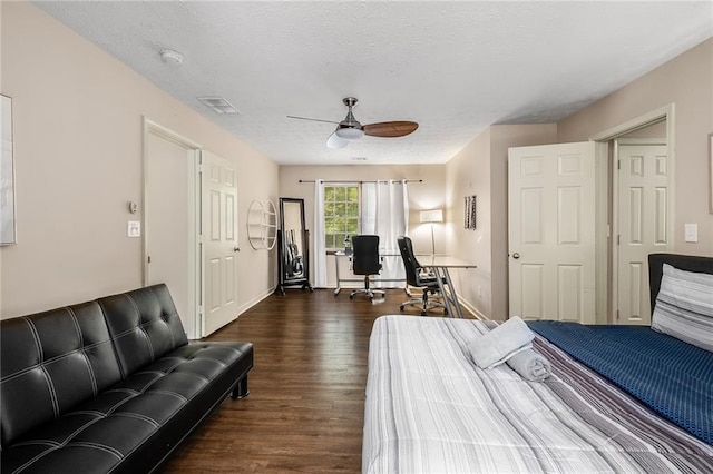 bedroom with ceiling fan, dark hardwood / wood-style flooring, and a textured ceiling