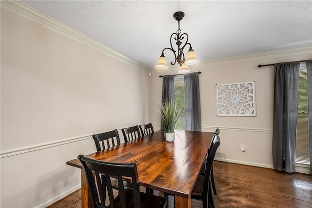 dining area with ornamental molding, a notable chandelier, and dark hardwood / wood-style floors