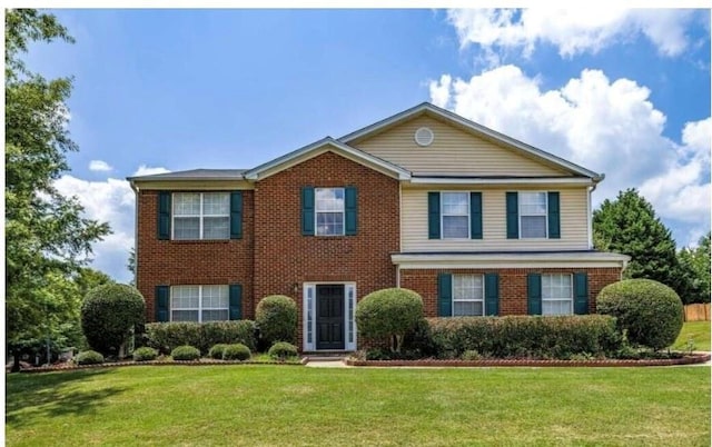 colonial house with brick siding and a front yard