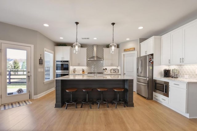 kitchen with stainless steel appliances, a kitchen breakfast bar, wall chimney exhaust hood, and decorative backsplash