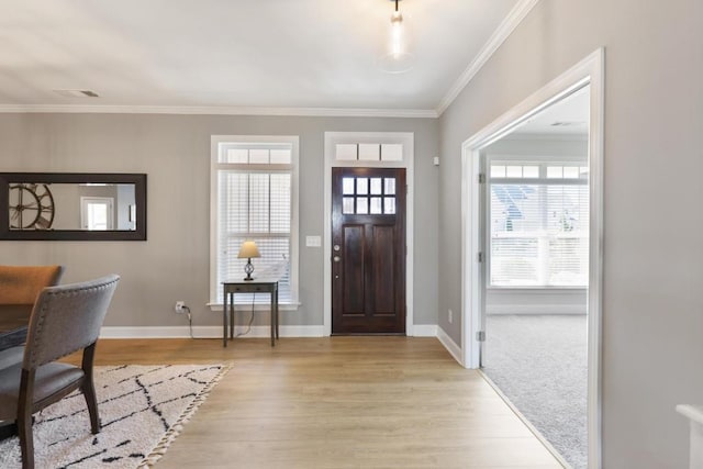 entryway with visible vents, ornamental molding, baseboards, and light wood-style floors