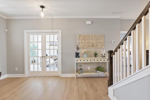 interior space with ornamental molding, baseboards, light wood finished floors, and stairs
