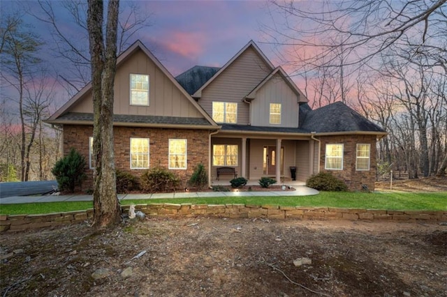 view of front of house with board and batten siding, a porch, and stone siding